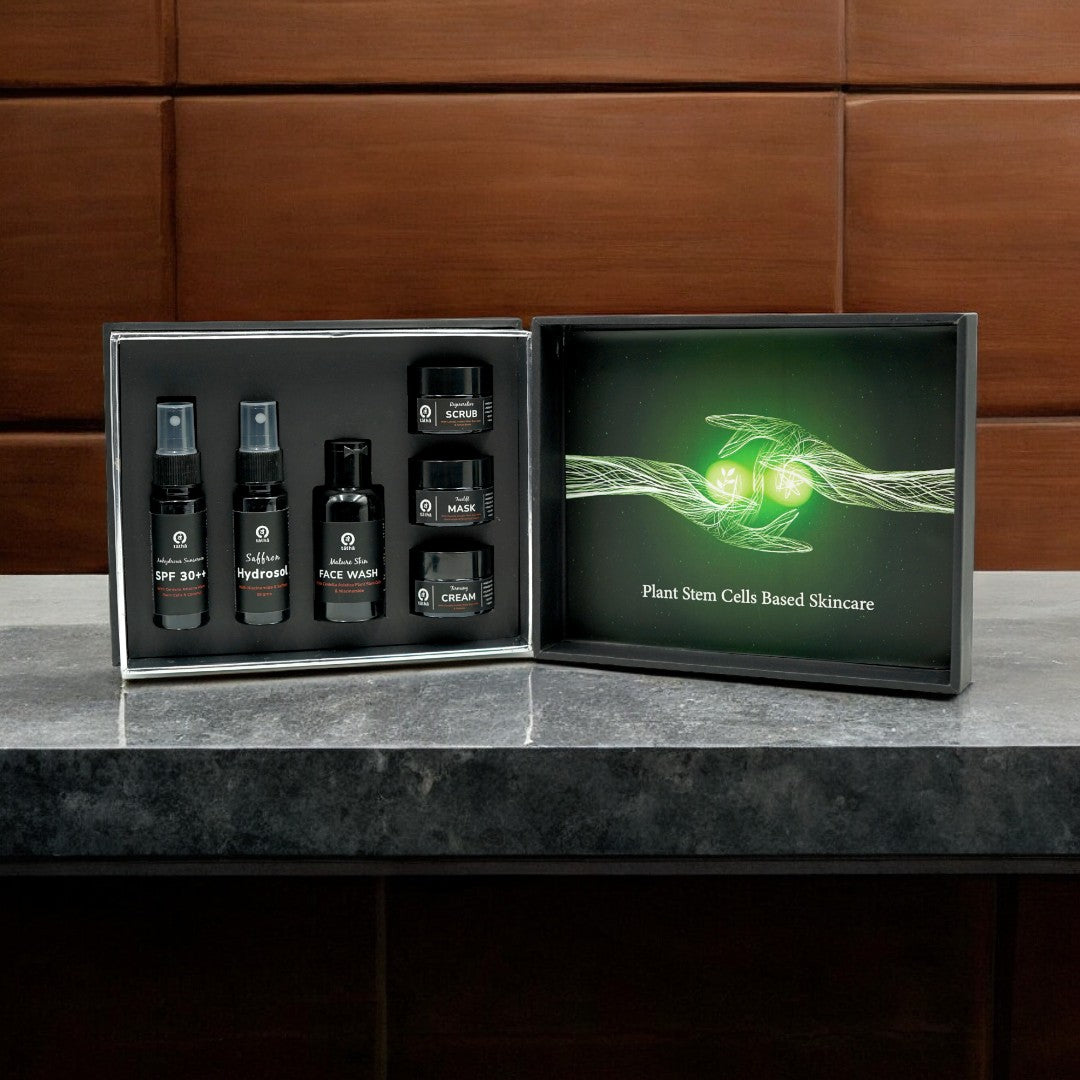 Open Tatha Nature's Blessings gift box with plant stem cell-based skincare products including SPF 30++ in black pump bottle, saffron hydrosol in black spray bottle, pore minimizing face wash in black bottle, regenerative scrub, firming cream, and facelift mask in black jars.