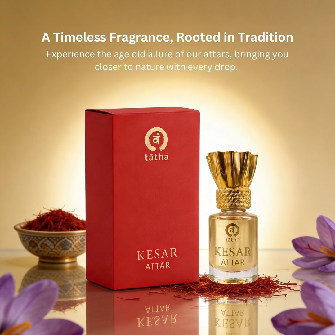 Kesar Attar with red box and saffron on a reflective surface with a warm glow.