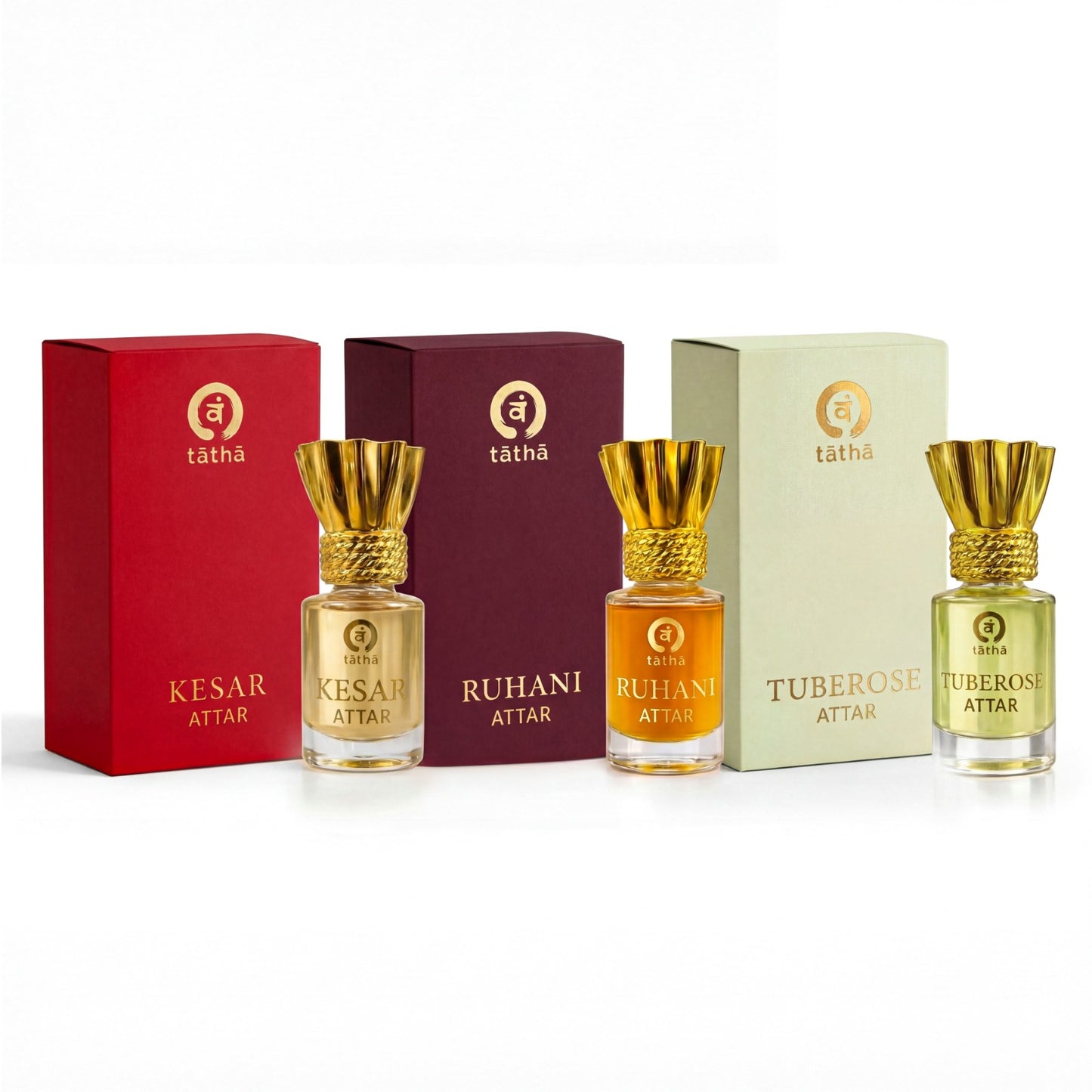 Three attar bottles with gold caps and different colored liquids, each in front of a matching colored box, on a white background.